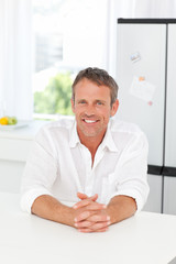 Fototapeta premium Handsome man sitting in his kitchen