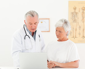 Doctor and his patient looking at the laptop