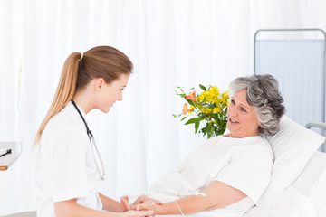 Nurse putting a drip on the arm of her patient