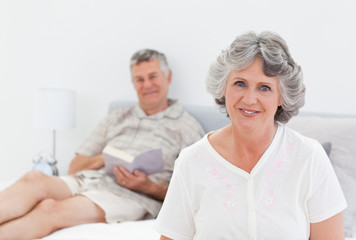 Obraz premium Woman working on her laptop while her husband is reading