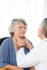 A senior doctor doing an examination of his patient