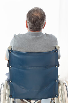 Mature Man In His Wheelchair With His Back To The Camera