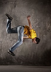 Fototapeta na wymiar Młody człowiek skacząc przed grunge ścianie