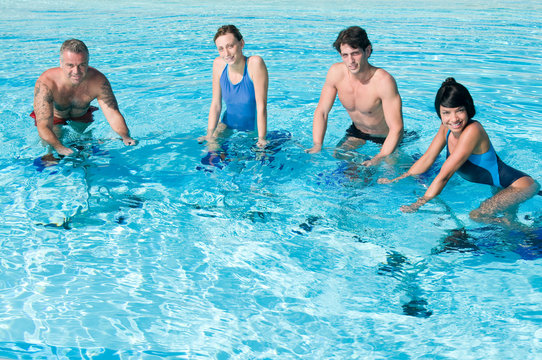 Happy People Exercising With Water Aqua Bike