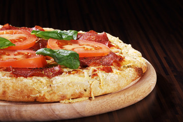 Salami Pizza auf Holzteller closeup