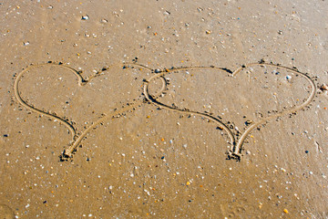 Fototapeta na wymiar Two hearts in the sand