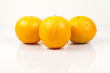 Three navel oranges on a white background