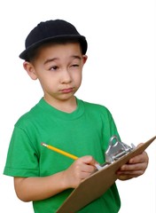 Boy writing on a clipboard tablet looking up thinking