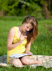 Beautiful young woman reading book outdoor