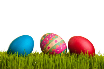 Easter eggs on green grass on white isolated backgr