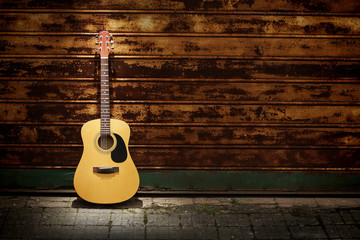 Fototapeta na wymiar Gitara akustyczna przed zardzewiałą bramą