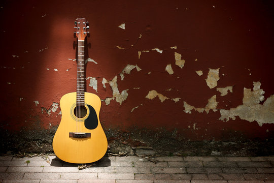 Acoustic guitar against grungy wall