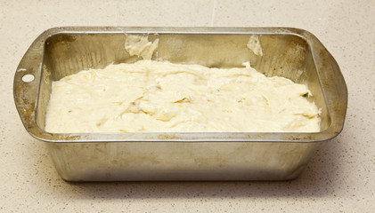 Banana bread dough in old tin ready for oven