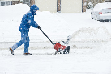 Man Clearing Sidewalk with a Snow Blower