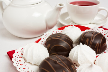Delicious chocolate and meringue cake with tea cup and teapot