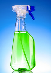 green spray bottle on blue background