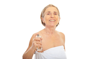 Senior woman applying perfume