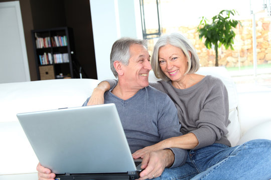 Senior couple surfing on internet at home