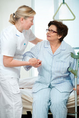 Nurse helps a patient to get up in hospital