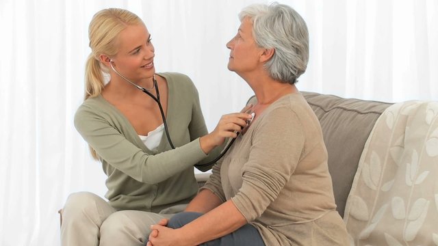 A nurse taking the pusle of her patient