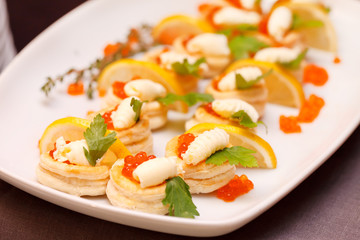 Canapes with red caviar and lemon