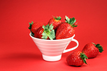Strawberry in cup on red