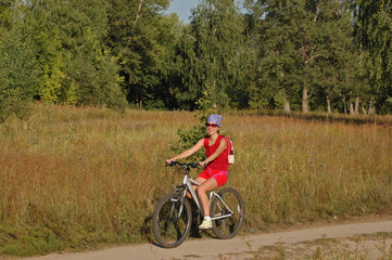 Naklejka premium Woman riding a bicycle in countryside
