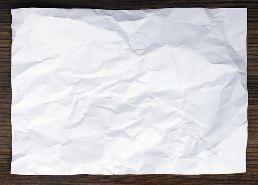 crumped white paper on wood background
