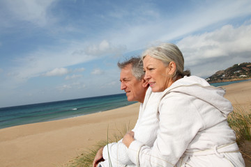Fototapeta na wymiar Senior couple in bathrobe at the beach