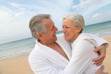 Senior couple in bathrobe at the beach