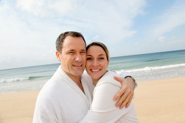 Couple relaxing in bathrobe at the beach