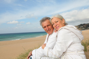 Senior couple in bathrobe at the beach