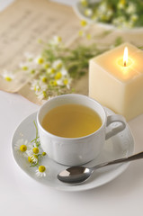 Taza blanca de manzanilla con flores frescas