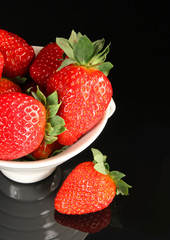 Strawberry in cup on black