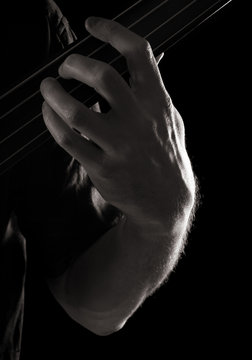 playing fretless electric bass guitar, toned monochrome image