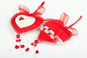 Red hearts of the textiles with beads and bow