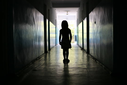Silhouette of the little girl in a long corridor