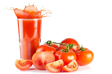 Ripe tomatoes and glass of tomato juice with splash