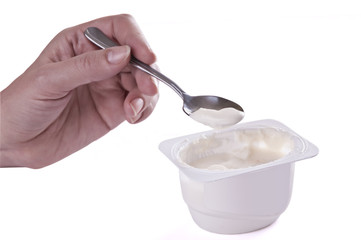 Tea spoon with yoghurt in a hand