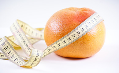 Grapefruit in the measuring tape, is isolated on a white