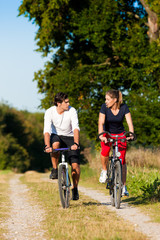 Mann und Frau beim Sport mit Fahrrad
