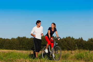 Mann und Frau beim Jogging und mit Fahrrad