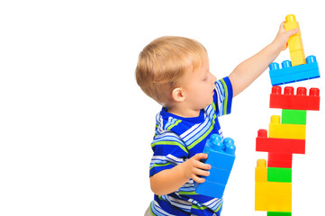 Cute little boy is playing with building blocks