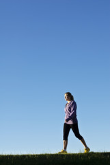 Fit woman walking while listening to music