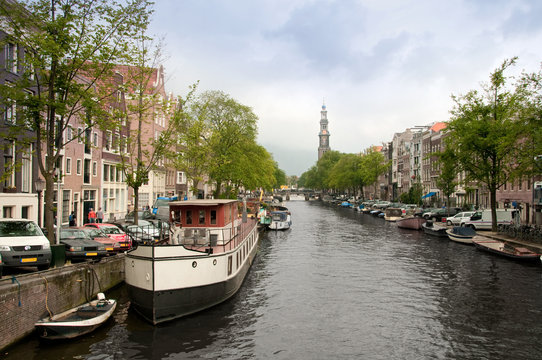 Typical Amsterdam's canal with and boats parked along it