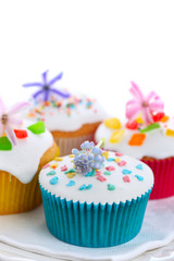 Easter cupcakes with spring flowers on white isolated background