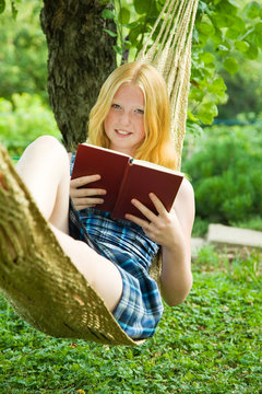 girl reading book on hammoc
