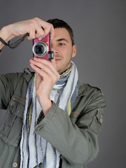 Young man with digital photo camera. isolated on white backgroun