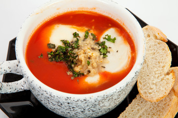 cup with tomato soup and bread