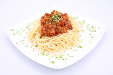 Spaghetti bolognese on a plate decorated with some chives